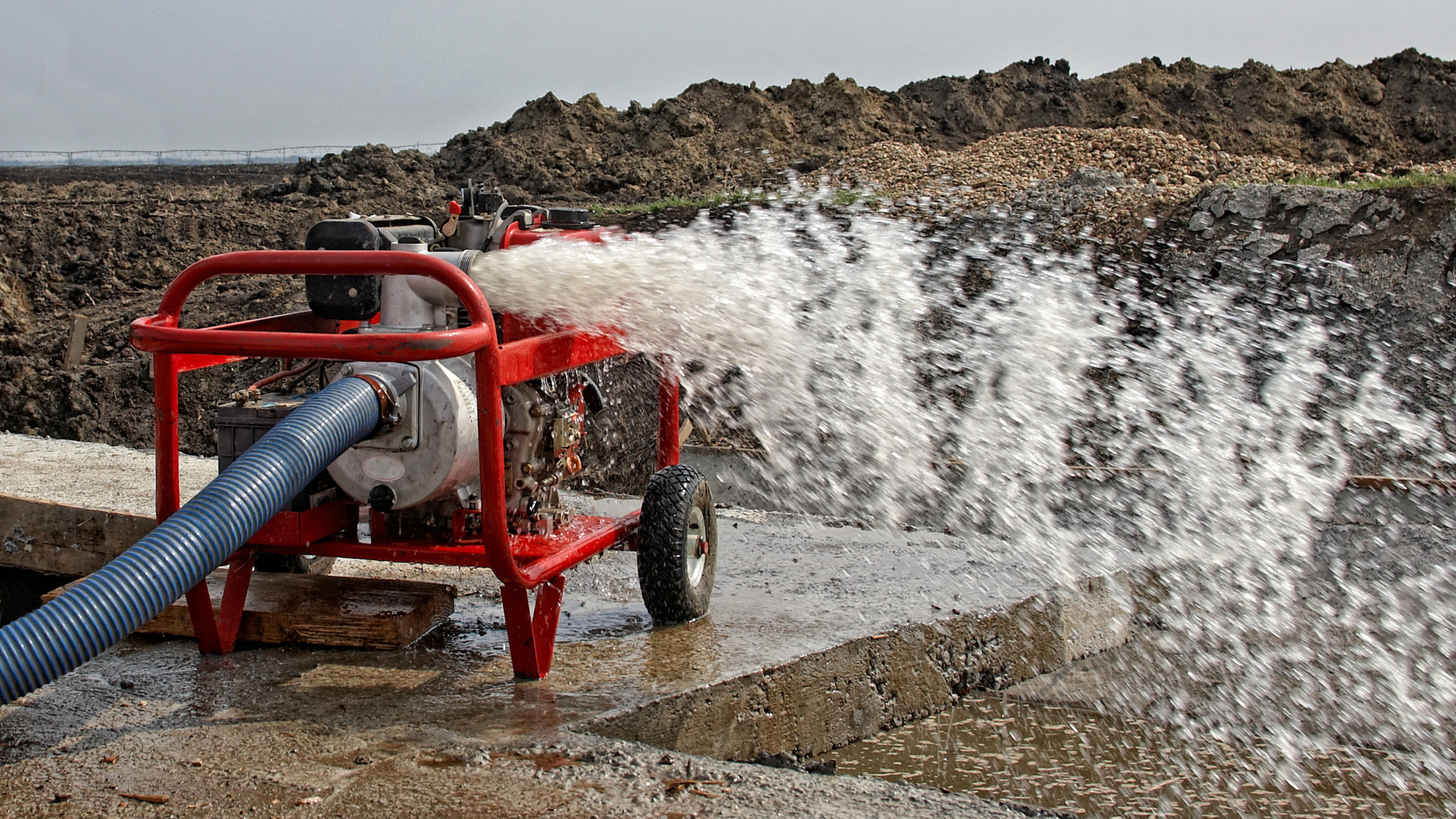 Field technician recording dewatering assessment data on a mobile device at a well head
